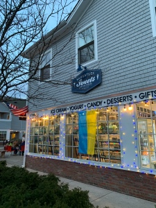Photo of Saugatuck Sweets with a Ukranian flag and blue and yellow lights.