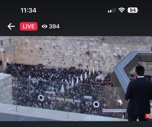 People saying prayers while facing the Holy of Holies at the Kotel in Jerusalem.